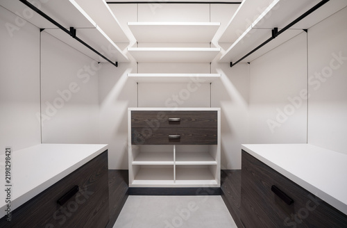 Картината върху платно Contemporary dressing room with built-in storage, dark wood cabinetry, open shel
