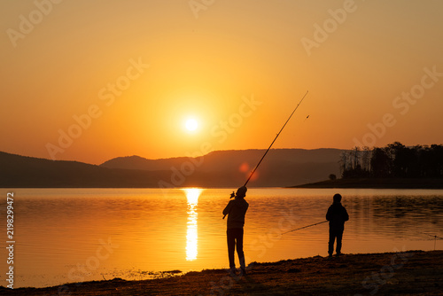 Father Son Fishing Silhouettes Lake Bank Sunrise Early Morning Golden Hour Sun Disk Family Relationship Bonding Casting Rod Hobby Kids Together Beautiful Nature Landscape Stock Photo
