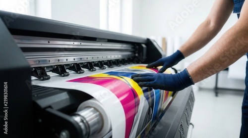 Tapety artystyczne Worker operating a wide format plotter printing colorful advertising