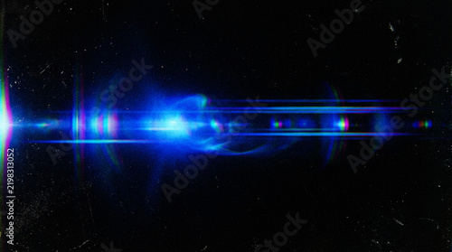 Blue anamorphic lens flare with horizontal light streaks and chromatic aberration on black background with subtle dust and scratches