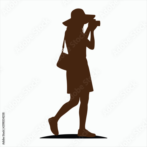 Silhouette of a woman with a hat taking a photo female
