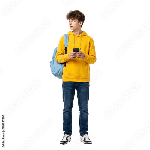 Young boy with backpack and smartphone, looking away, isolated