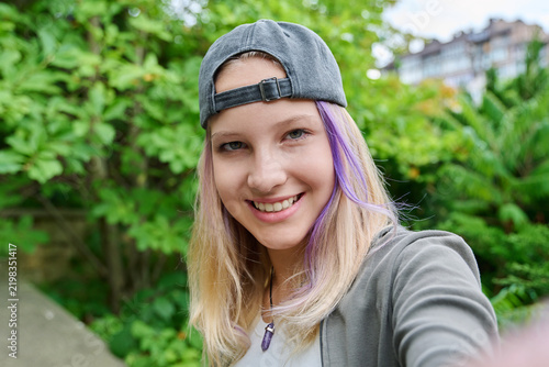 Obraz na plátne Teenage girl taking selfie outdoors looking at camera close up portrait