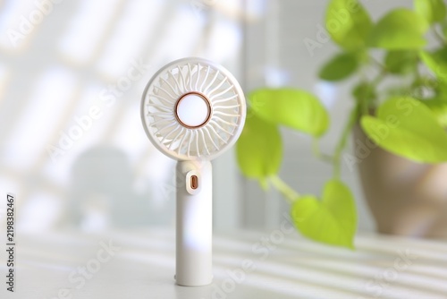 Mini fan on white table indoors, closeup. Space for text