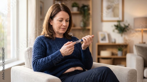 Diabetes self-monitoring and glycemic control: mature senior woman sitting at domestic table using lancet device to test blood glucose level on finger. Detailed clinical photography image.