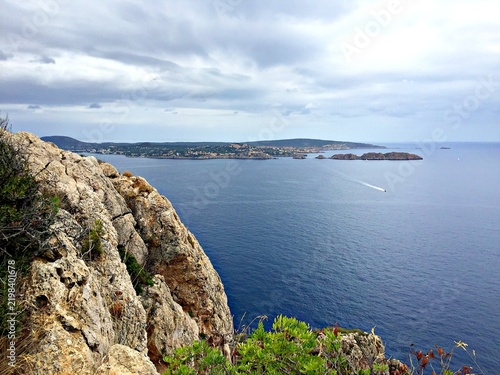 Quadro su tela Rugged cliff overlooking a vast blue ocean and distant coastline