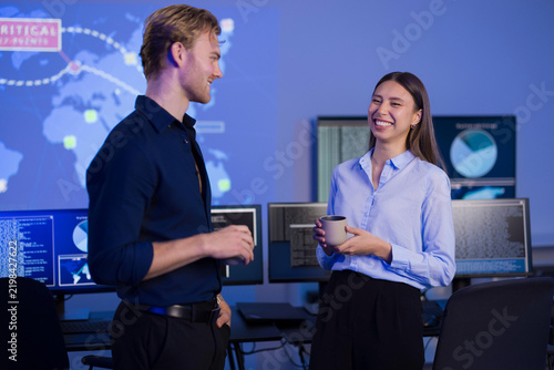 Cybersecurity team discussing strategies in a control room with digital interfaces