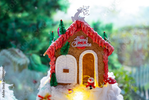 Festive Christmas miniature village with decorated gingerbread houses, cotton snow, tiny trees, ornaments, and warm glowing lights for holiday home decor. made by kids at home