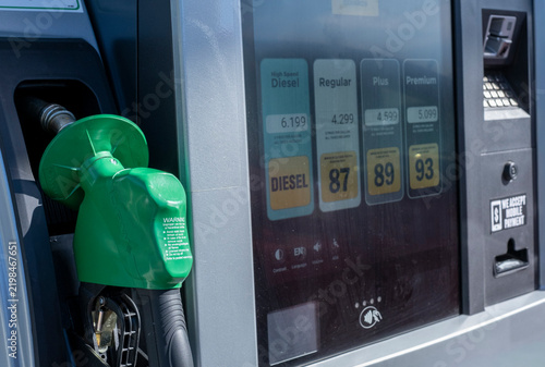 Gas station pump nozzle with fuel prices on digital screen
