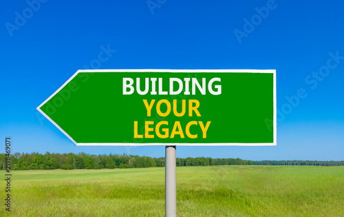 Building your legacy words symbol. Concept words Building your legacy on beautiful green road sign. Beautiful blue sky green grass background. Business building your legacy concept. Copy space.