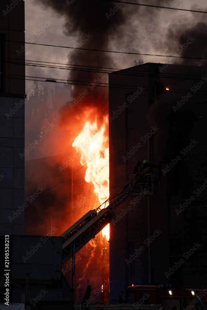 Obraz premium Firefighters put out the burning building of the shopping center. Smoke and fire after a drone attack in Ukraine, rescuers are working at the scene