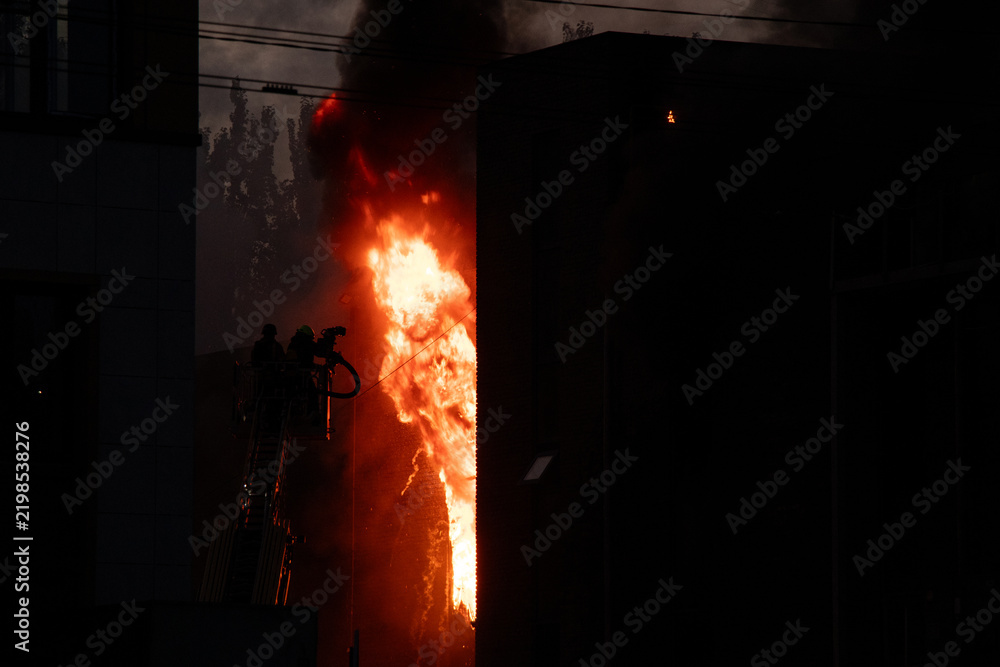 Obraz premium Firefighters put out the burning building of the shopping center. Smoke and fire after a drone attack in Ukraine, rescuers are working at the scene