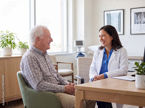 Cheerful Senior Man Smiling at Female Doctor in Clinic Consultation