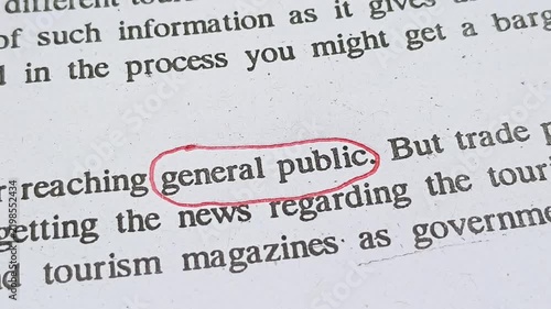 Closeup of hand with red ink pen mark circle around to emphasize or highlight General Public word on news paper article page. Ordinary or common working class people problems concept.