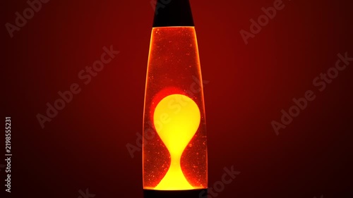 Glowing Orange Lava Lamp with Floating Yellow Wax Bubbles Against Red Background, Retro Psychedelic Mood Lighting