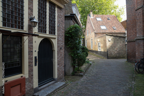 Historic cobblestone alley with traditional brick houses in the historic city center of Enkhuizen.