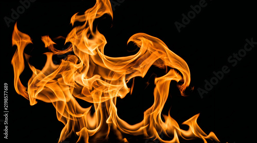 Bright orange flames of fire burning and dancing with intense heat against a dark background
