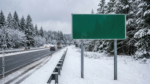 Blank Green Road Sign Along Snowy Forest Highway Travel