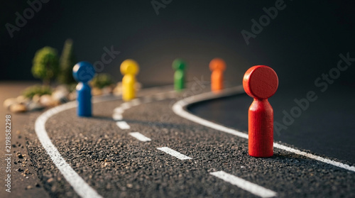 Colorful pawns on winding road: concept of journey, decision, strategy, future