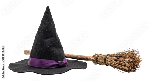 Картината върху платно Black witch hat with a purple ribbon and a rustic wooden broomstick on a white b