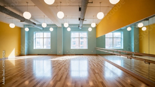 Empty dance studio with reflective mirrors and exposed ceiling lights