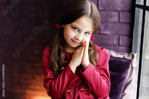 Portrait of Smiling Girl in Red Dress with Clasped Hands