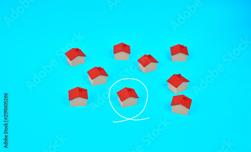 Fotografie One miniature house circled among several homes represents property selection home buying and targeted real estate search