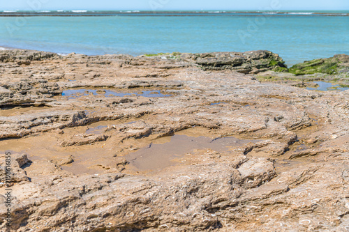 Beach in Chipiona with rocks in foreground, Cadiz, Spain