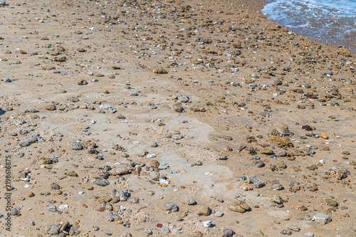 Beach detail with small rocks and seashells on sand