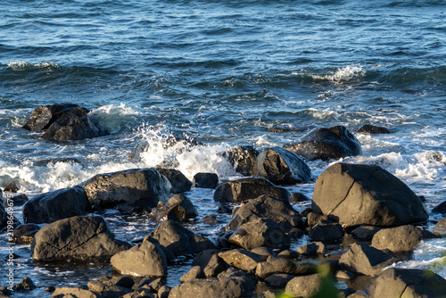 Foto Rocky foreshore with small waves washing and splashing