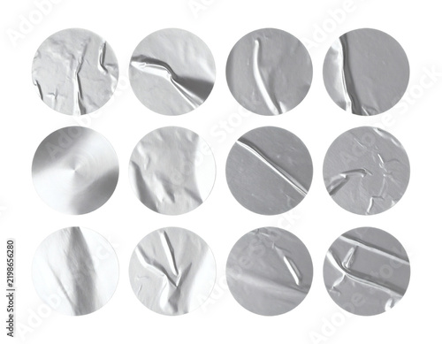 Silver sticker set featuring various wrinkled metallic circular adhesive labels with realistic creased foil textures isolated in a collection for graphic design projects 