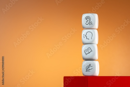 Stacked white cubes with listening, speaking, reading, and writing icons. Language learning, communication skills, education concept.