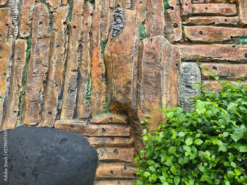 Faux Stone Relief Wall Background with Green Plants