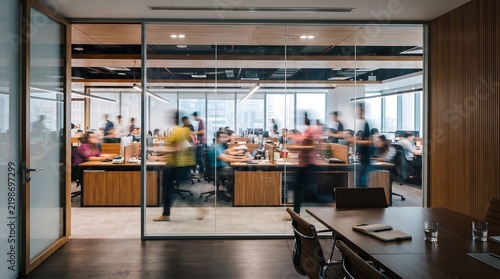Busy modern open space office with glass partitions and employees working inside.