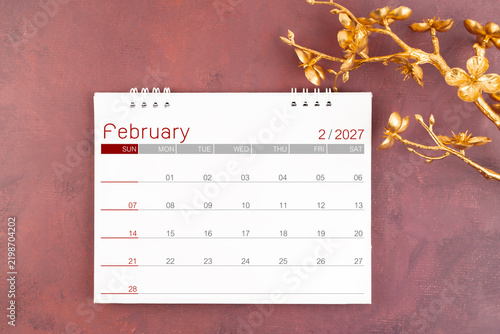 Desk calendar for February 2027 year with gold cherry blossoms branch.