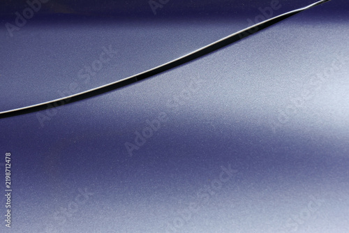 Фотография Abstract metallic surface with curved black line and soft blue gradient creating