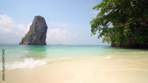 Ko Poda beach with tree and tourist boat on blue sea ocean to marine by slow motion wave with mountain island for daylight seascape and nature landscape to summer holiday travel at Krabi in Thailand