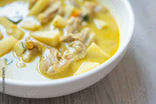 Фотография Creamy chicken potato soup with carrot and herb in white bowl