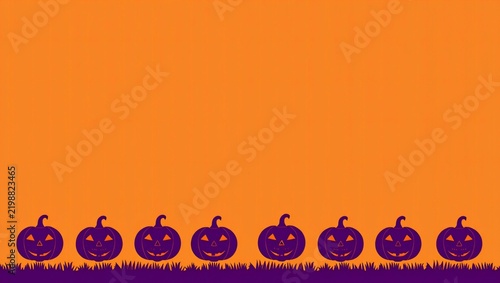 Row of purple carved jack o lantern pumpkins on grass against an orange background for halloween