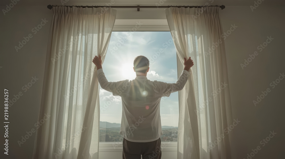 Obraz premium New beginning concept showing anonymous person opening curtain toward sunrise