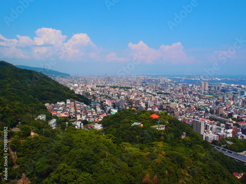 Фотография High angle view of sprawling city nestled against green mountain slopes