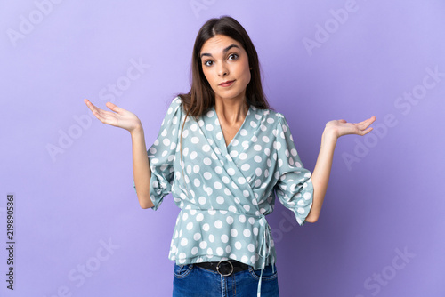 Foto Young caucasian woman isolated on blue background having doubts while raising ha