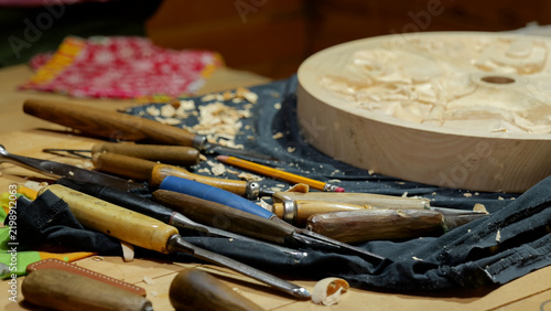 Canvastavla Woodcarving chisels and carved wooden panel on workbench with wood shavings and