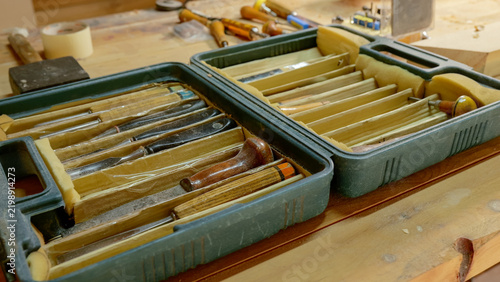 Cuadro en lienzo Set of woodcarving chisels in foam lined plastic case on workbench, with chisel,