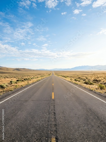 Endless open road stretching into the horizon under a vast blue sky.