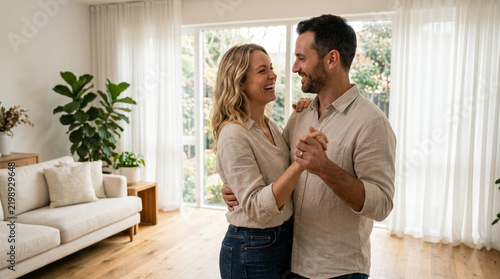 Happy couple dancing in bright living room, embracing with joy