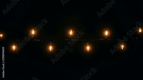 Warm glowing light bulb on dark wire