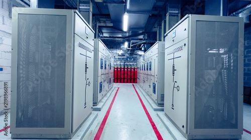 Electrical control panel room in industrial plant with power distribution cabinets, switchgear, and safety equipment.