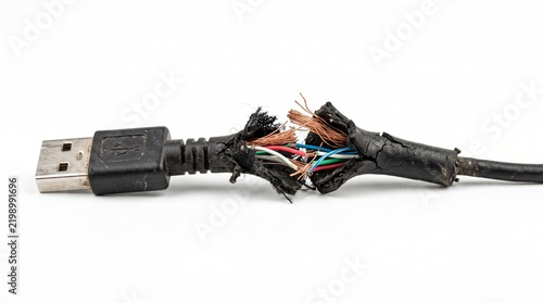 Critically damaged USB cable, insulation torn to reveal frayed internal wires, highlighting electronic malfunction and urgent replacement