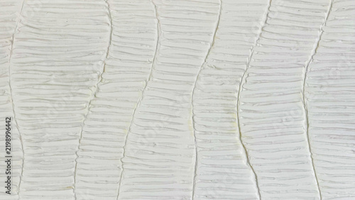 Abstract white plaster wall texture with handmade uneven lines and organic relief pattern, neutral textured background for interior design and creative projects.